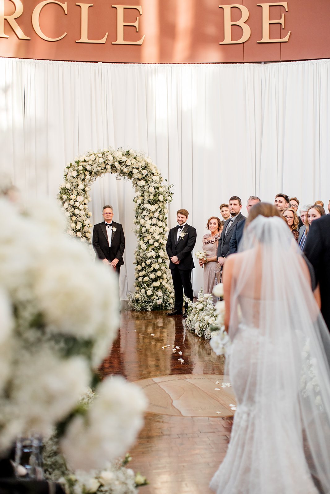 Bride walking down the aisle towards groom and officiant.