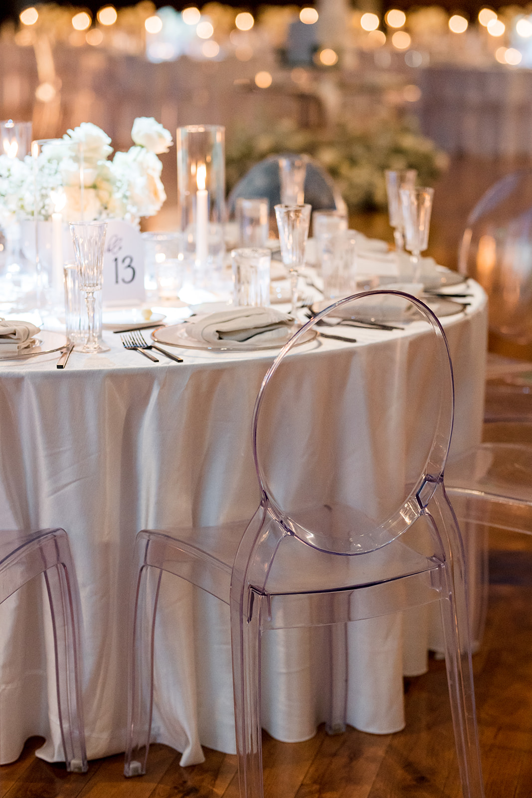 Formal tablescape of dinner setting, florals, lighting, table numbers and menus.