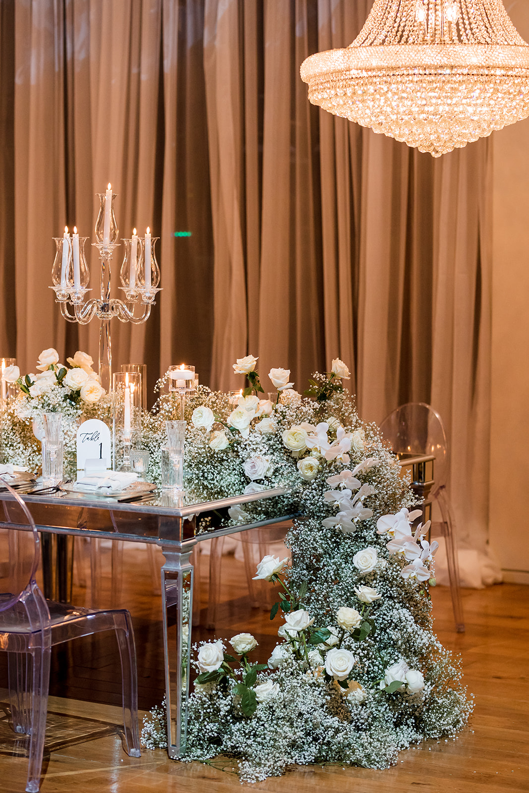 Formal tablescape of dinner setting, florals, lighting, table numbers and menus.