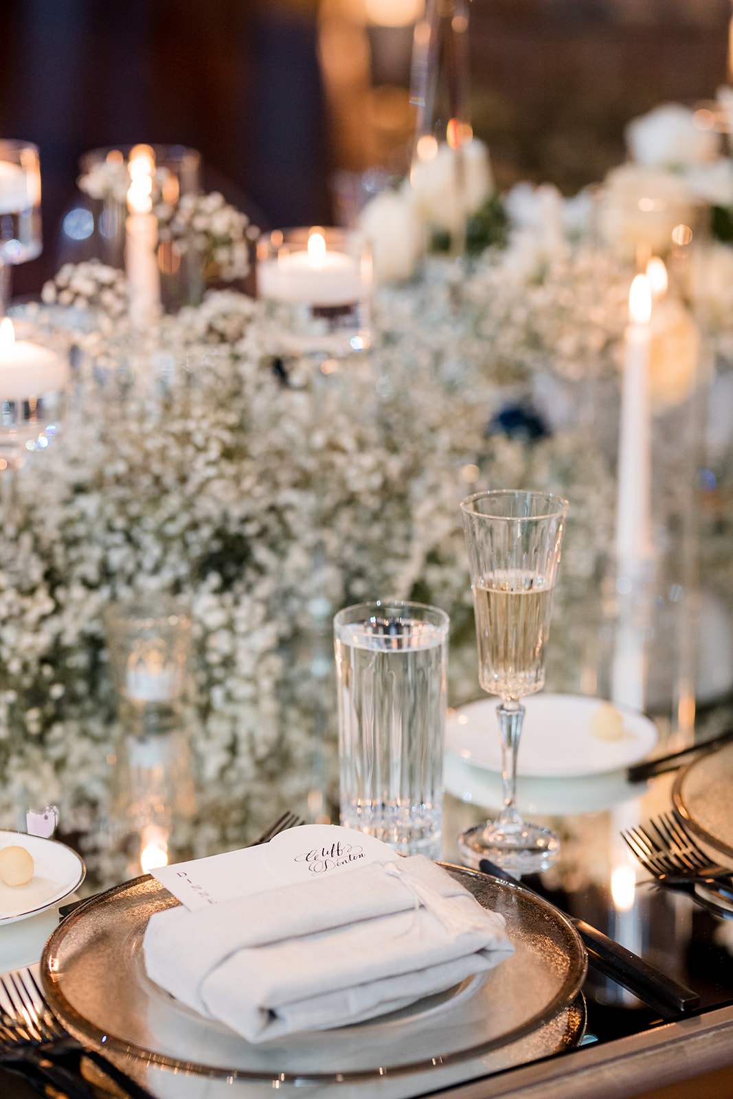 Formal table setting with custom menu tucked into napkin on plate.