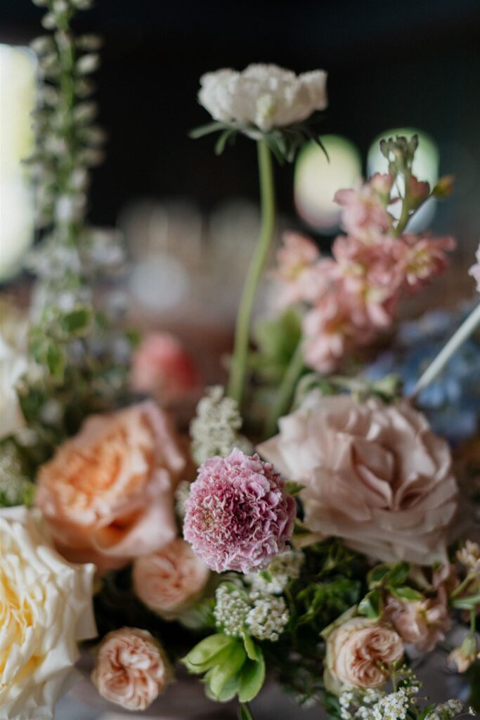 Floral arrangement decor sits on top of white-linen dining table.