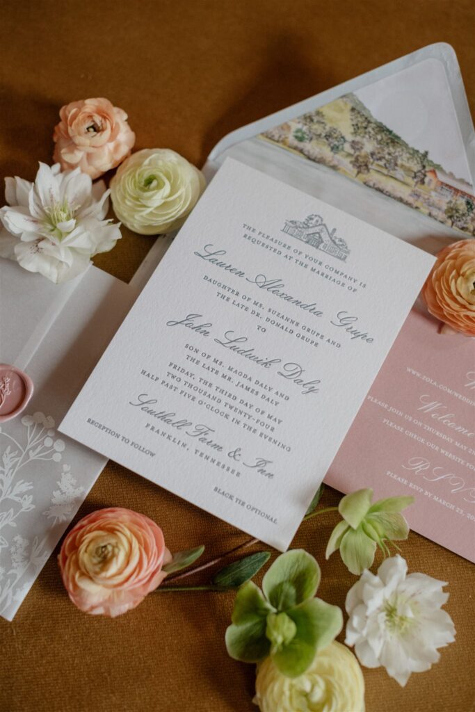 Flat lay of formal wedding invitation suite decorated with flowers.