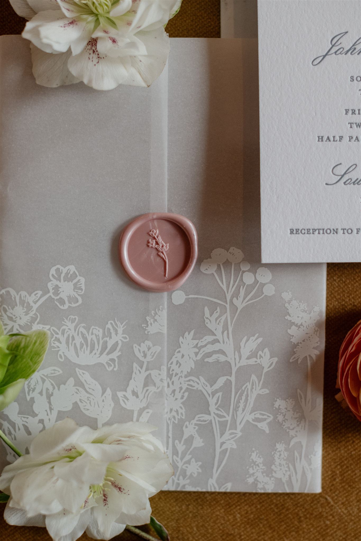 Flat lay of formal wedding invitation suite decorated with flowers.