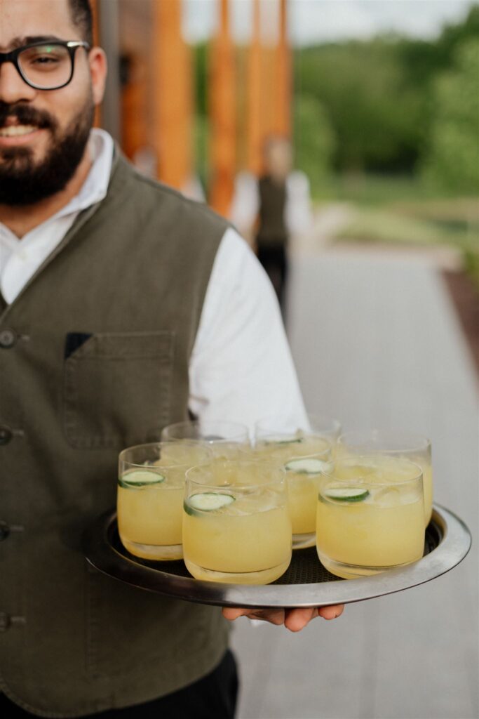 Server carrying a tray of cocktails.