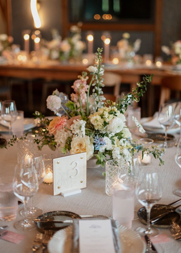 Formal reception dining place setting with table menus, candles and floral arrangements.