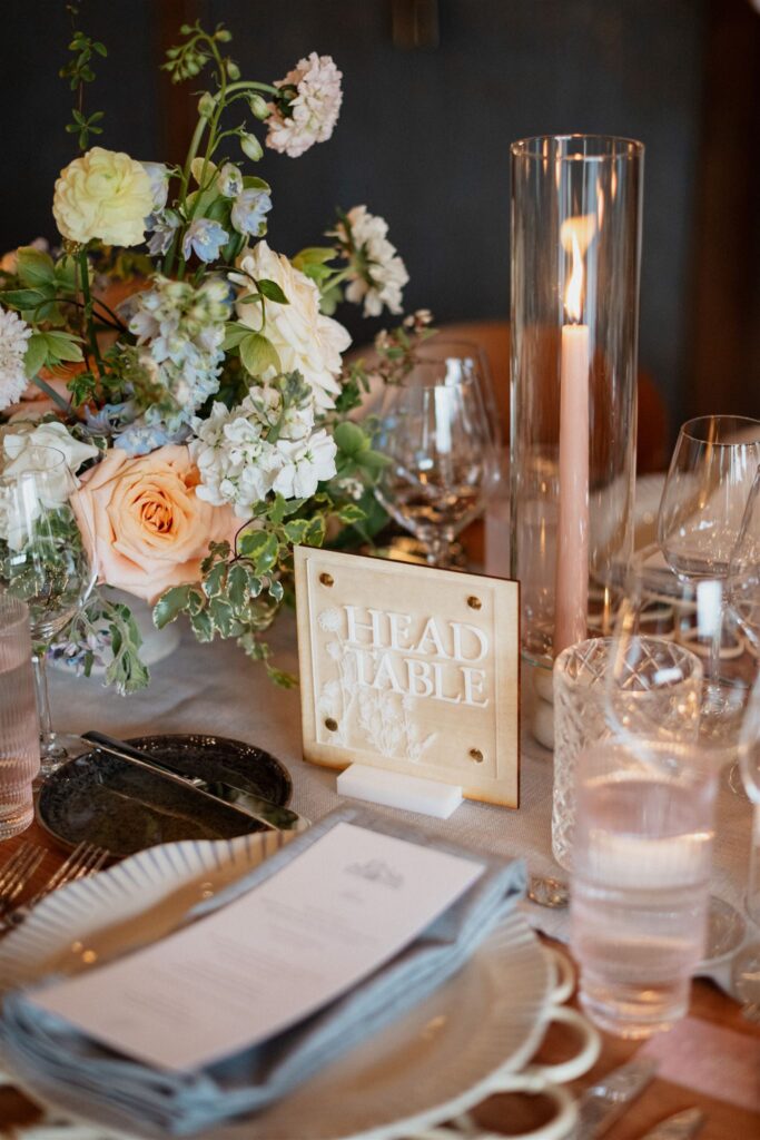 Formal reception dining place setting with table menus, candles and floral arrangements.