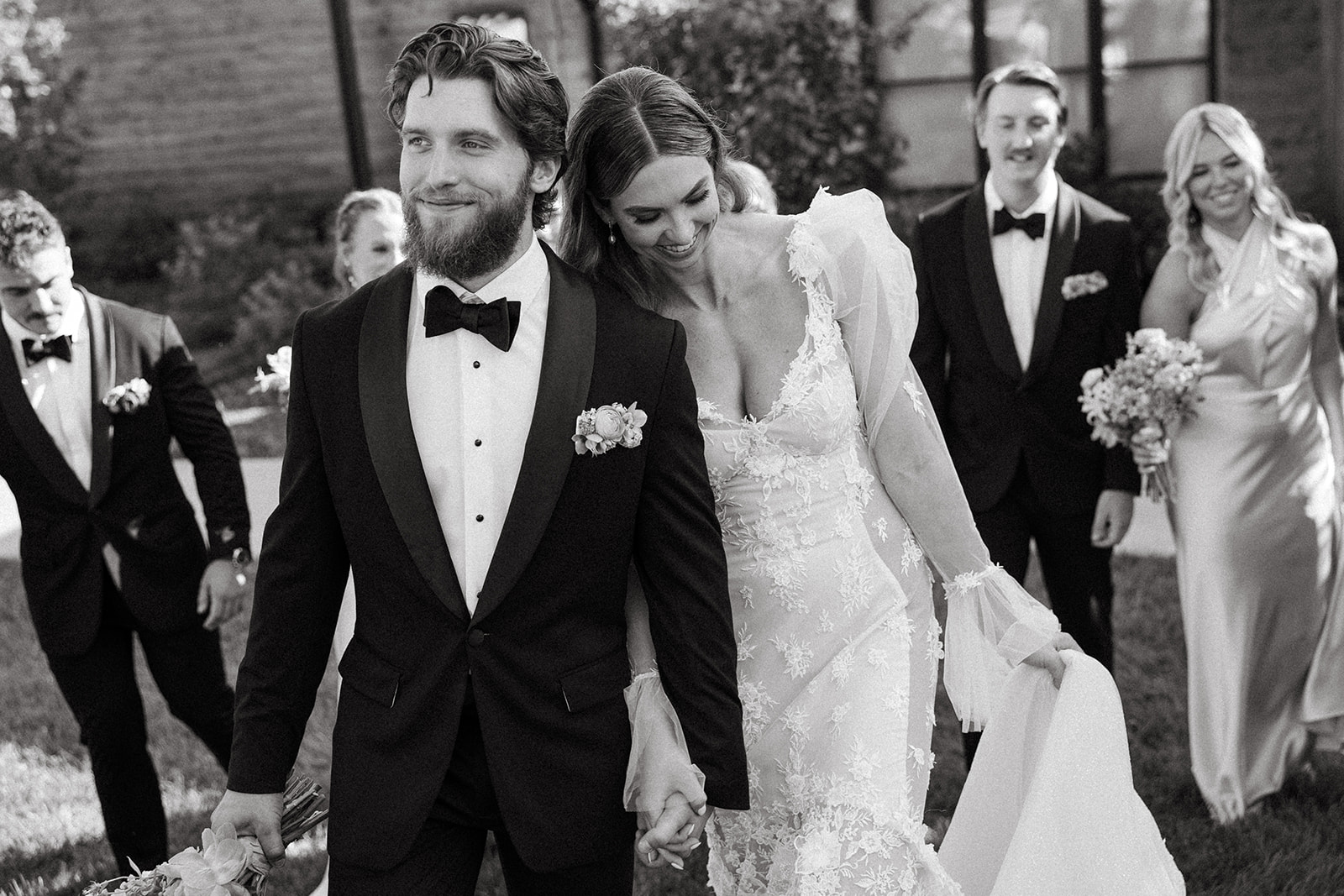 Bride and Groom walk hand in hand down the aisle as they smile.