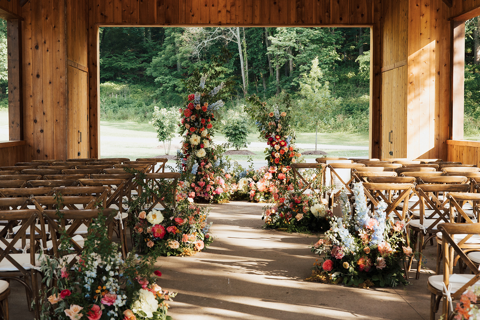 Ceremony venue styled with lots of florals and floral arbor.