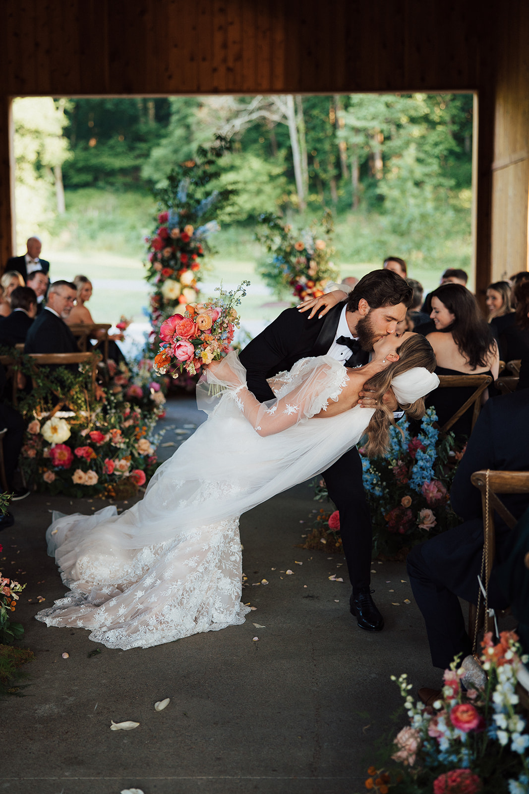 Groom dips bride as he kisses her on their way up the aisle.