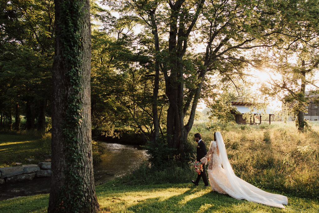 Bride and groom share a picturesque walk together in beautiful outdoor setting.