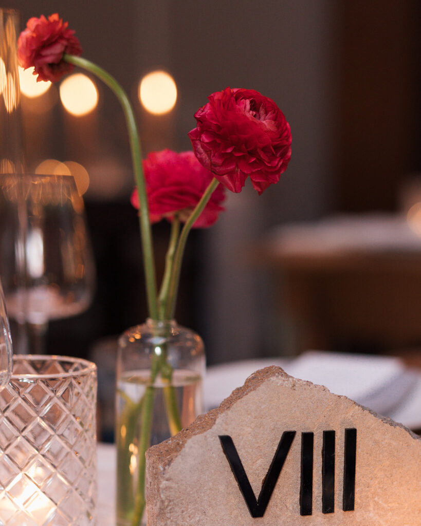 Formal reception table setting with stone, Roman numeral table number in center.