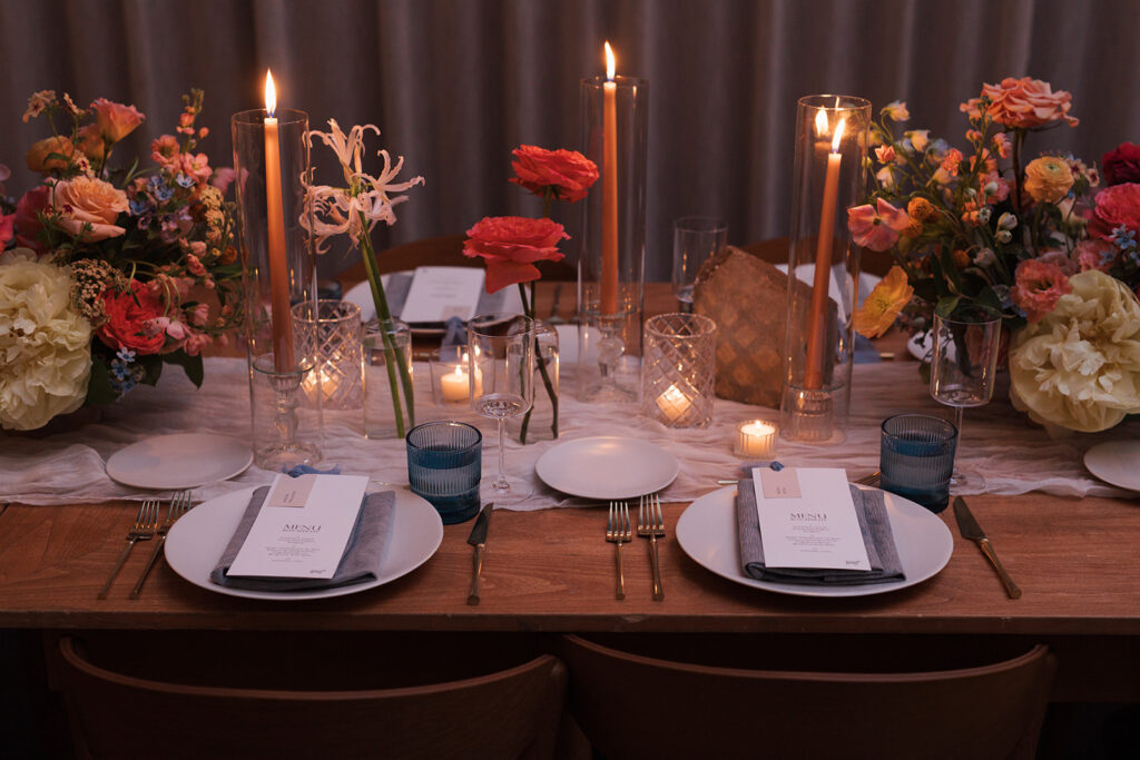 Formal reception tablescape to include candles, place settings, florals, and custom menus.