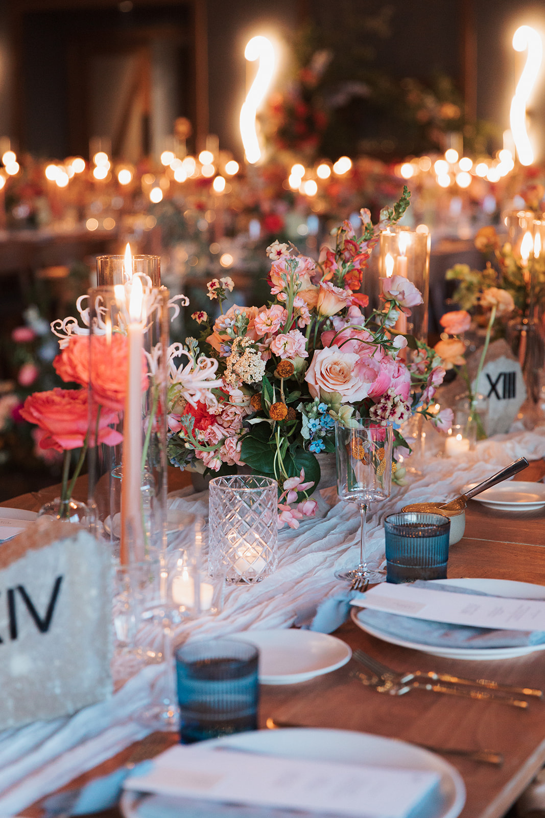 Formal Textured Wedding reception Details including candles, place settings, florals, and custom menus.