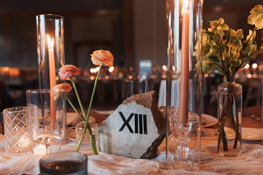 Formal reception table setting with stone, Roman numeral table number in center.