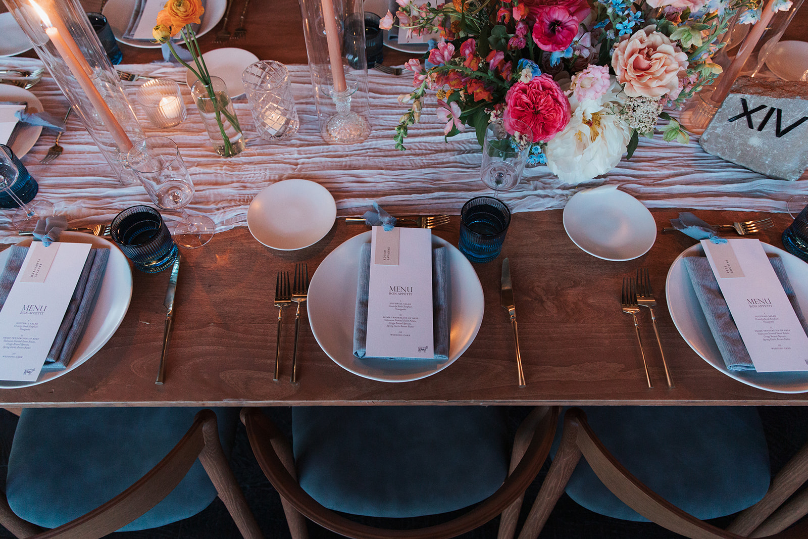 Formal reception tablescape with Textured Wedding Details including candles, place settings, florals, and custom menus.  