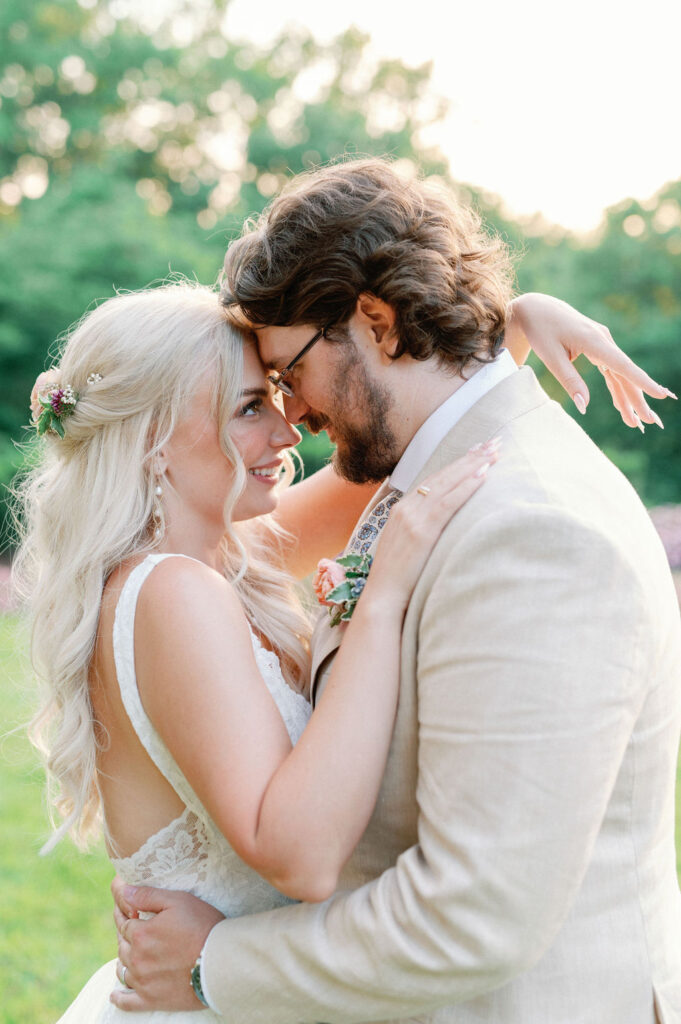 Bride and groom share an embrace and stare outdoors.