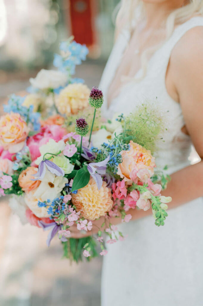 Colorful bride's bouquet held by bride's hands