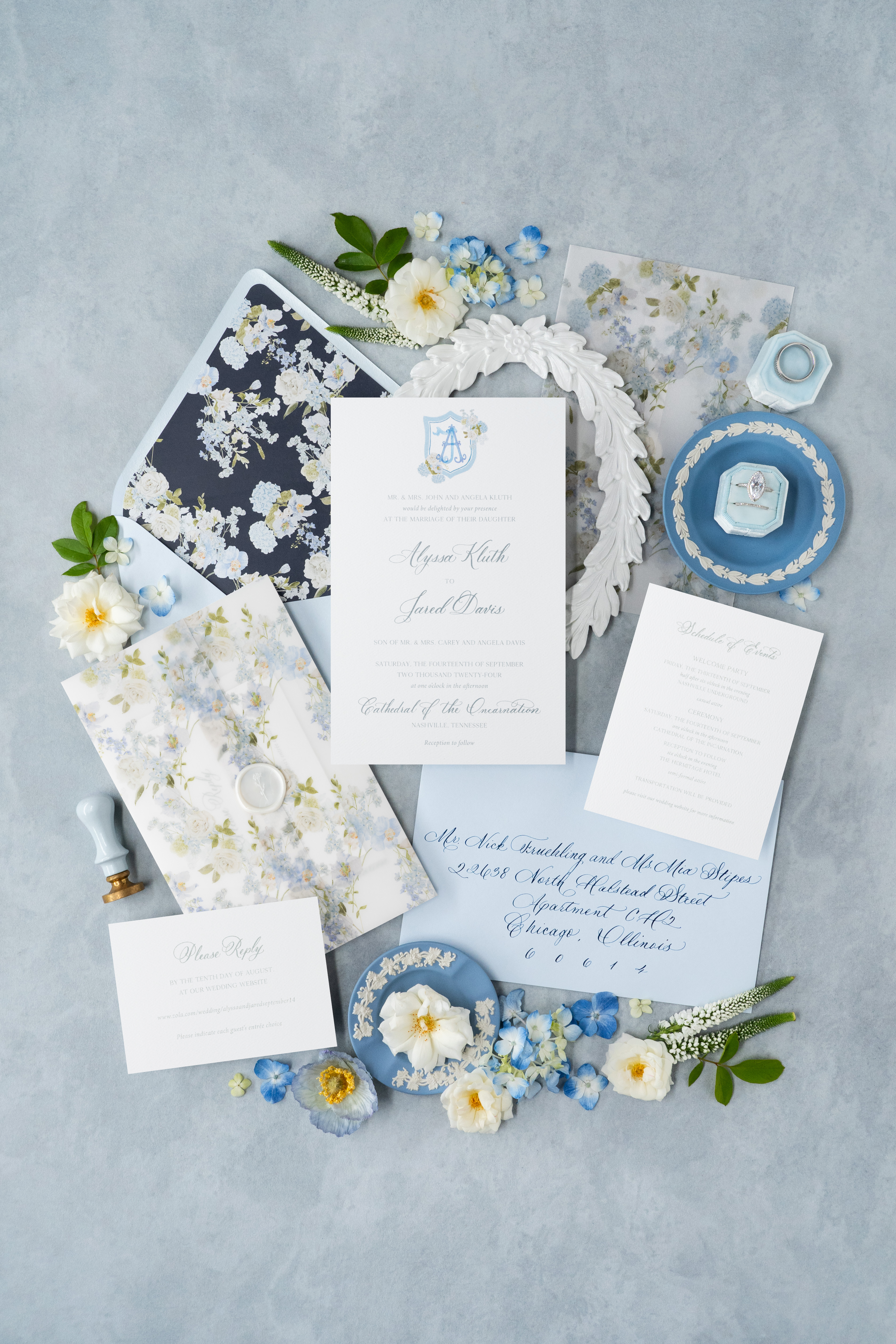 Custom wedding invitation suite flat lay styled with florals and vintage decor.