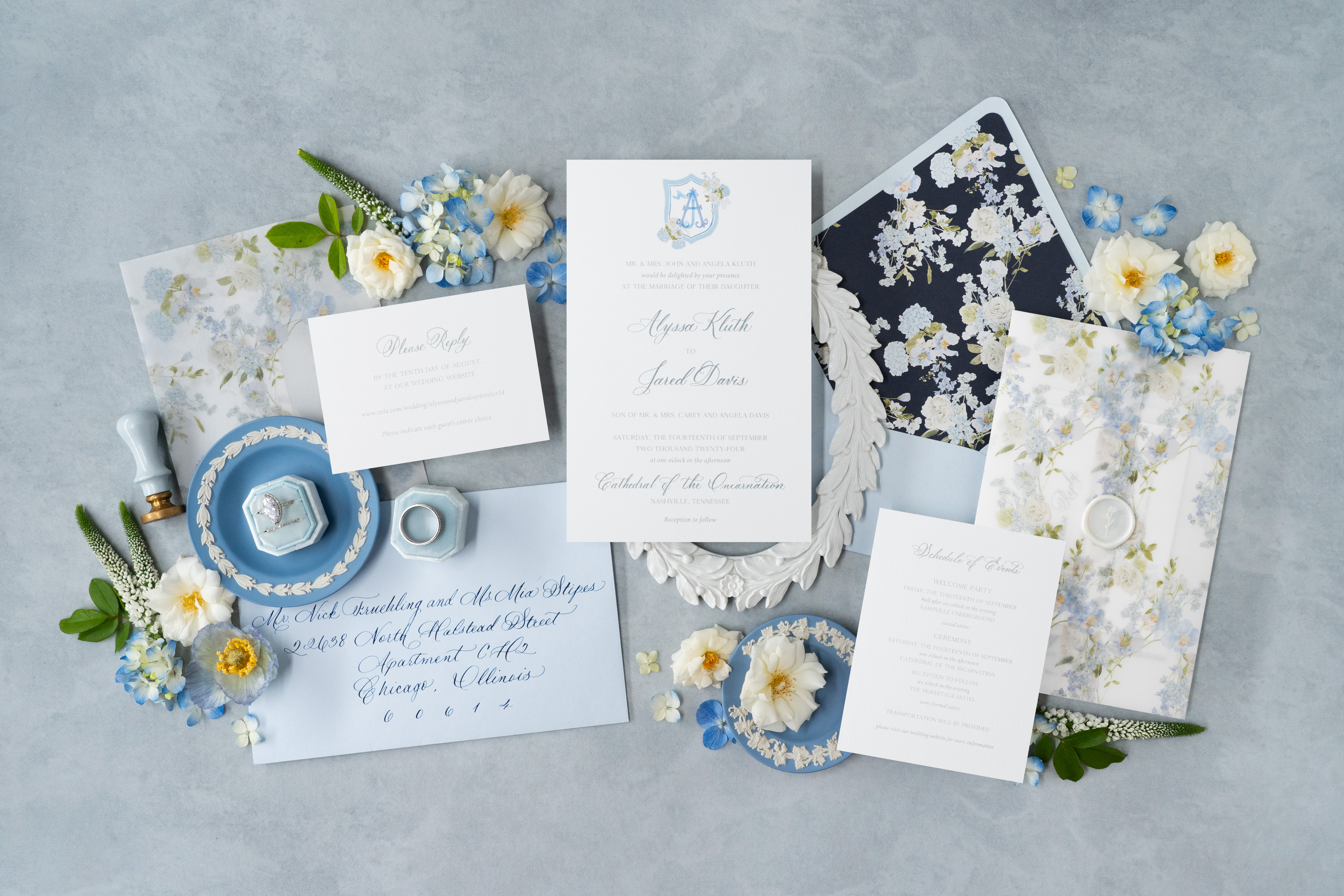 Custom wedding invitation suite flat lay styled with florals and vintage decor.