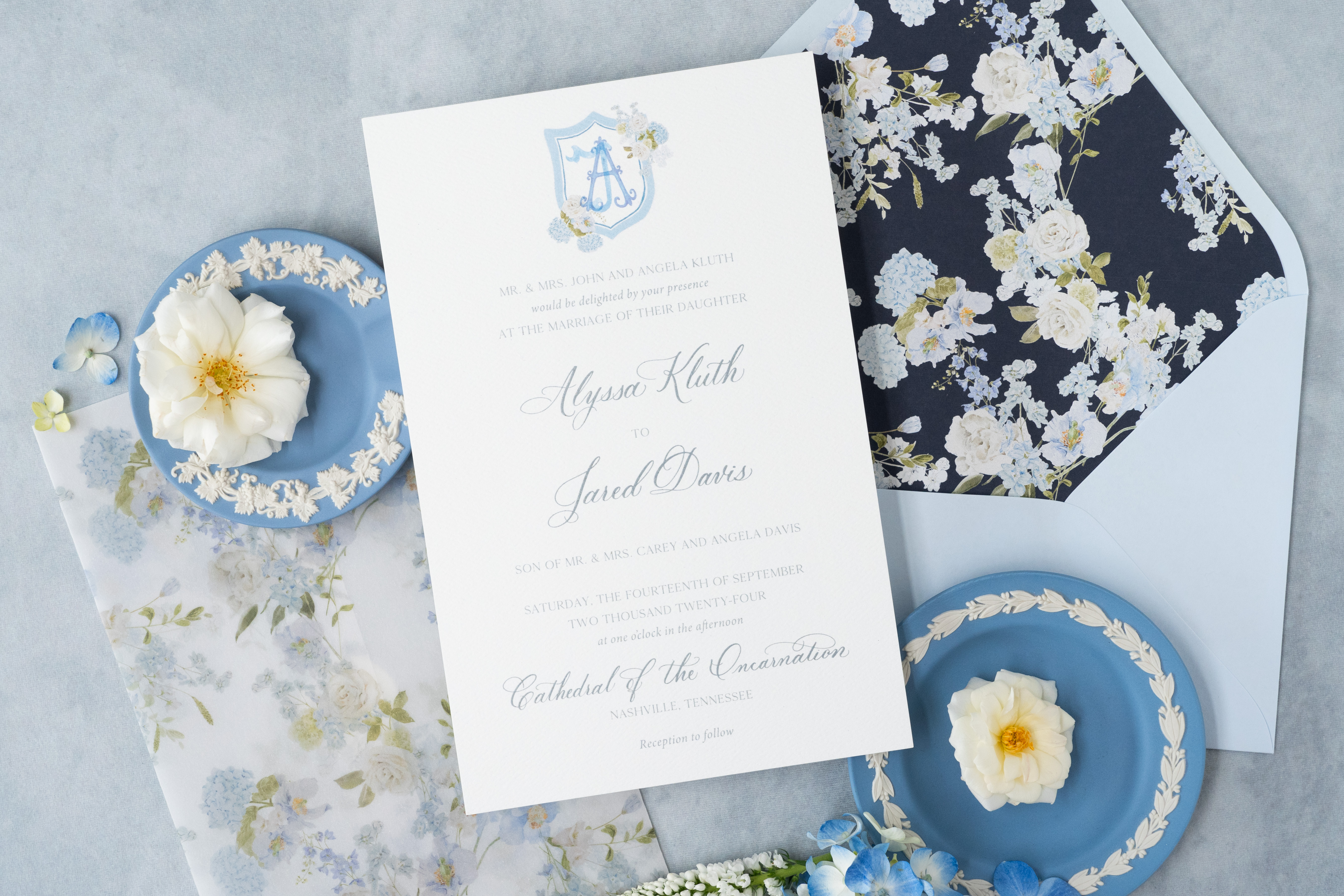 Custom wedding invitation suite flat lay styled with florals and vintage decor.