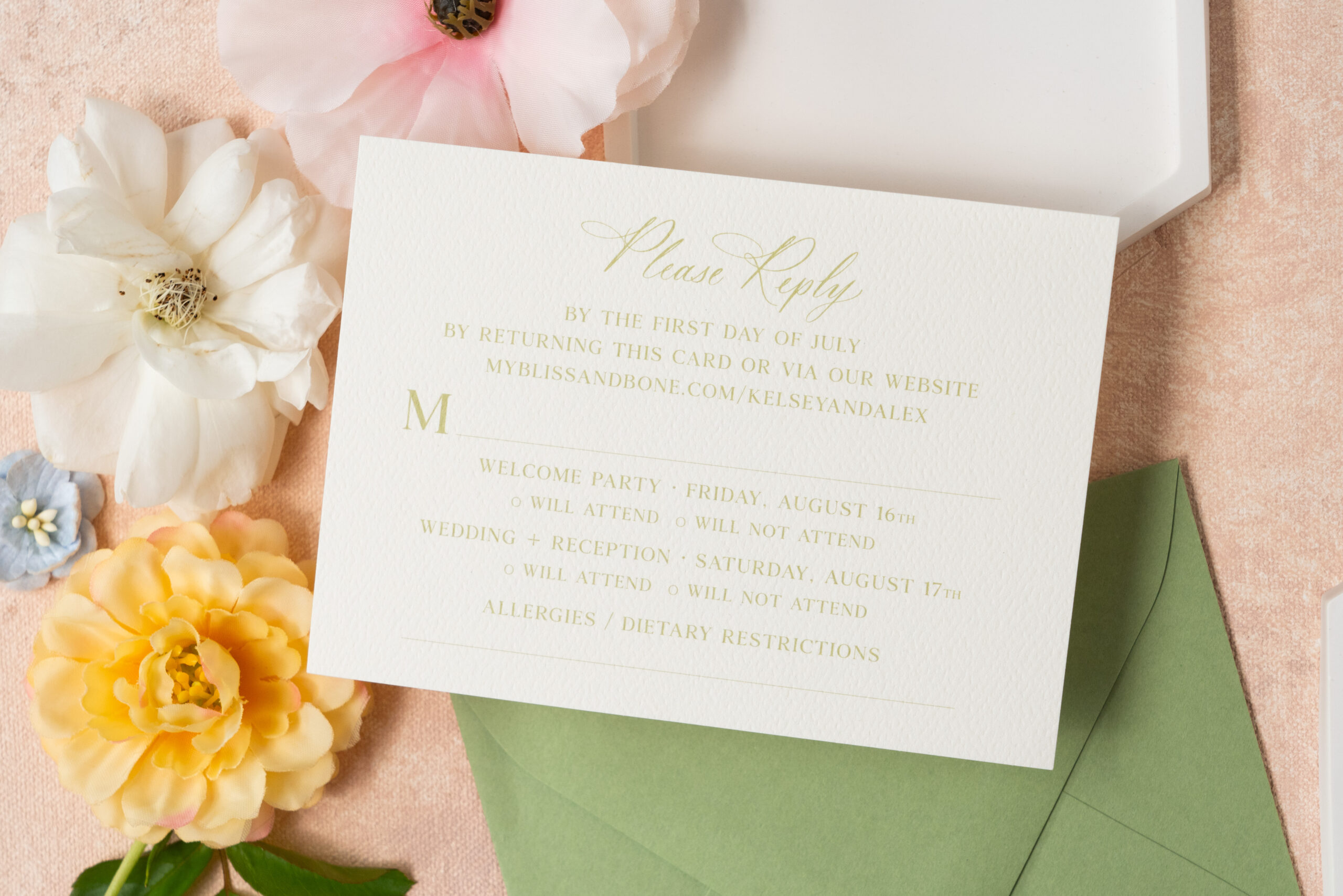 flat lay of custom wedding invitation reply card. styled with florals.