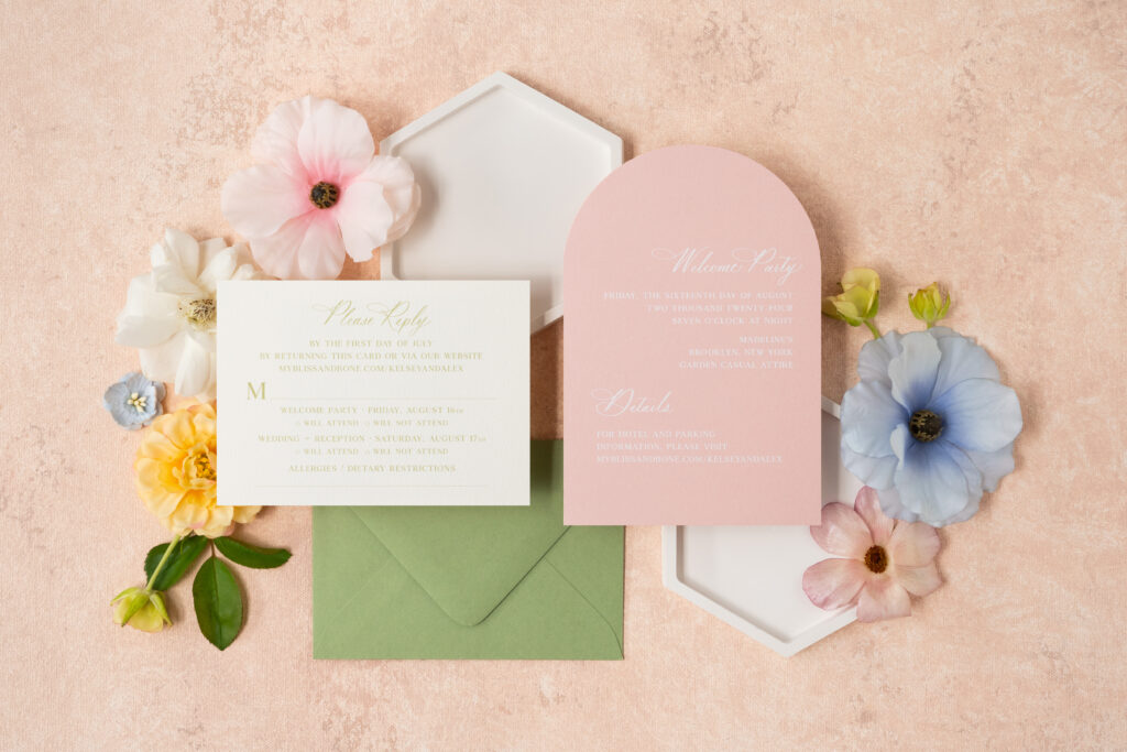 Custom wedding invitation suite showcasing custom die-cut pocket, custom architectural sketch, summer pinks, greens, envelope calligraphy, and custom envelope liner.