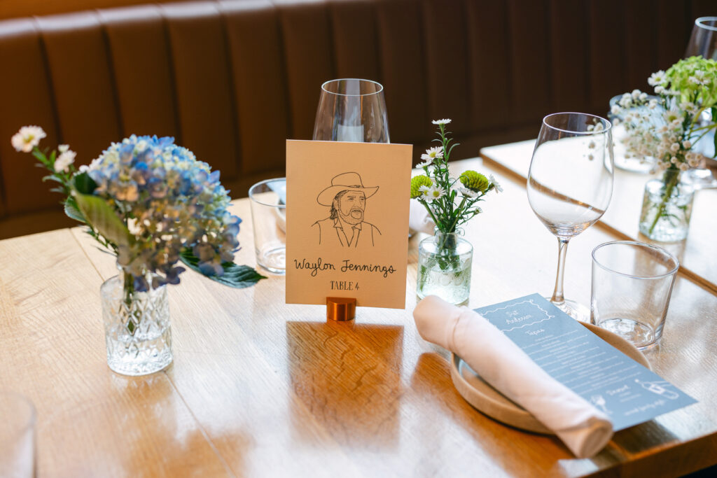 Custom table number signage sits among tablescape for rehearsal dinner.