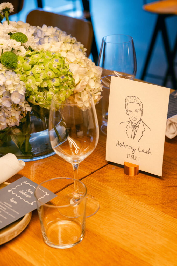 Custom table number signage sits among tablescape for rehearsal dinner.