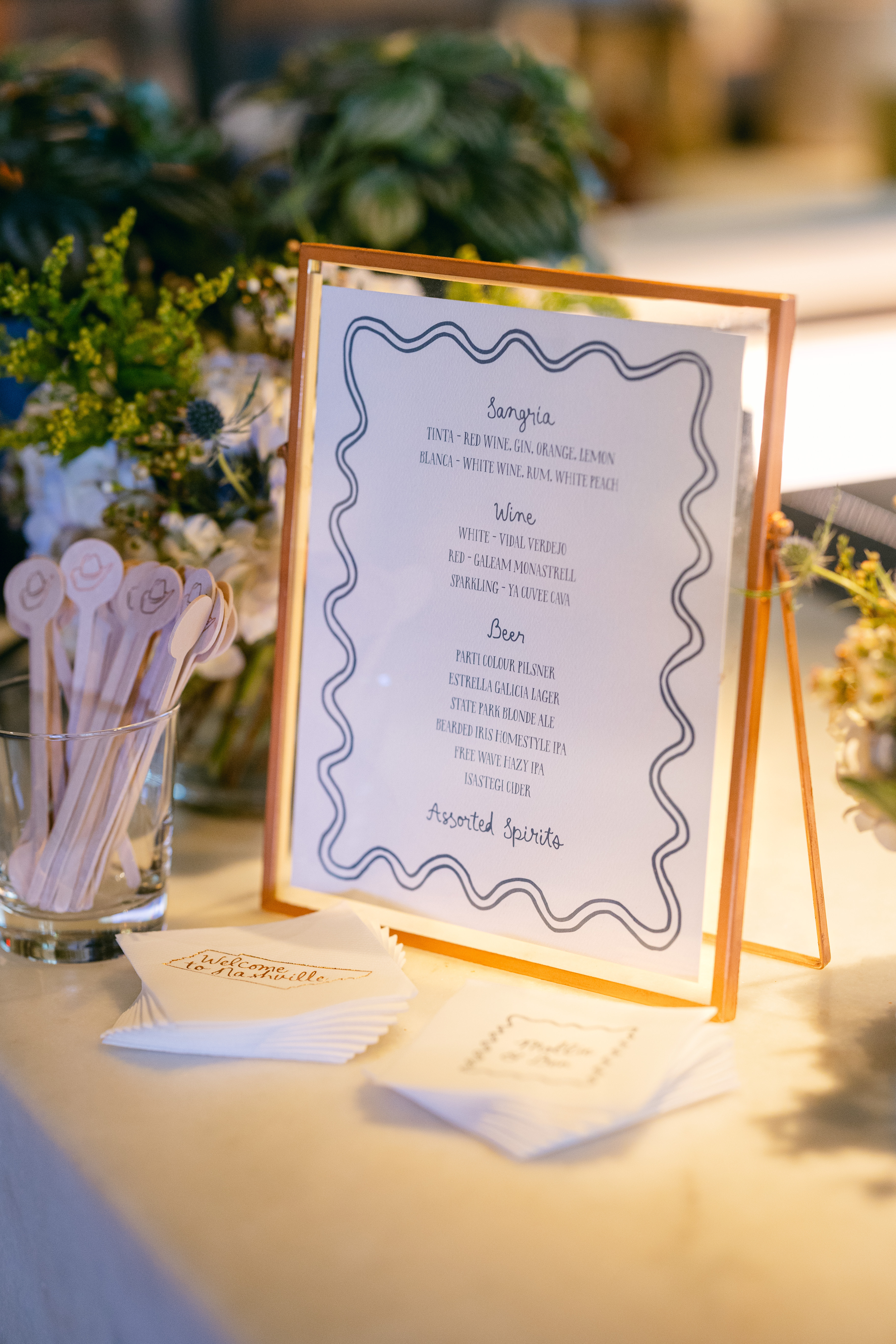 Custom rehearsal dinner bar signage, cocktail napkins and drink stirrers.