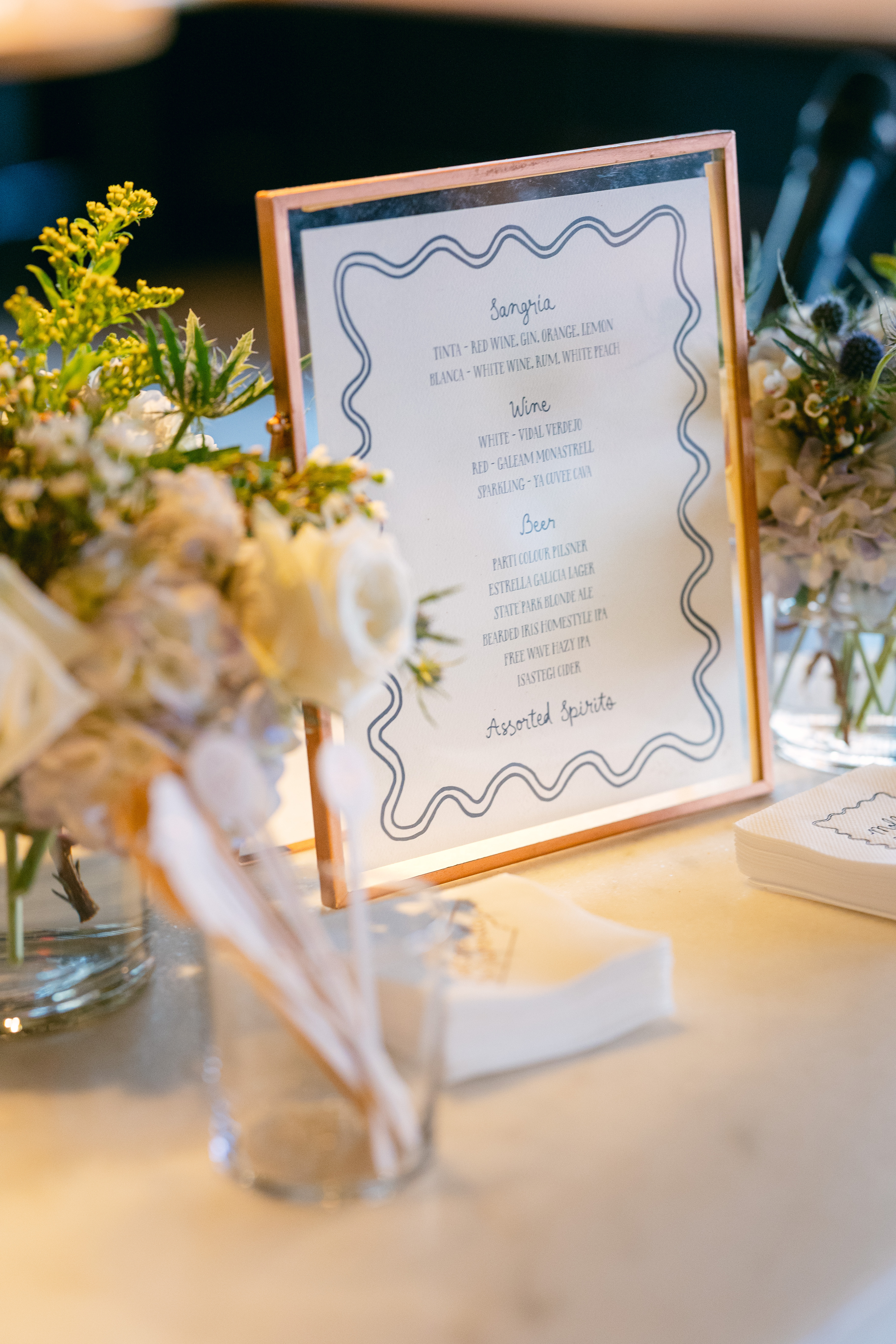 Custom rehearsal dinner bar signage, cocktail napkins and drink stirrers.