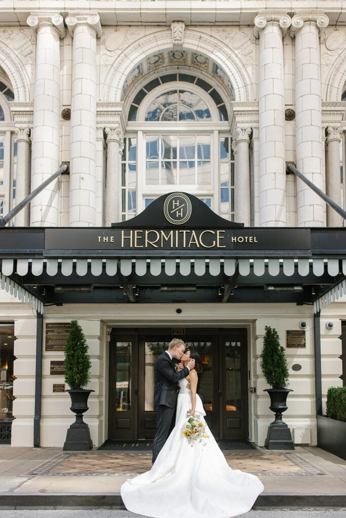 Bride and groom share a kiss outside of The Hermitage Hotel entrance.