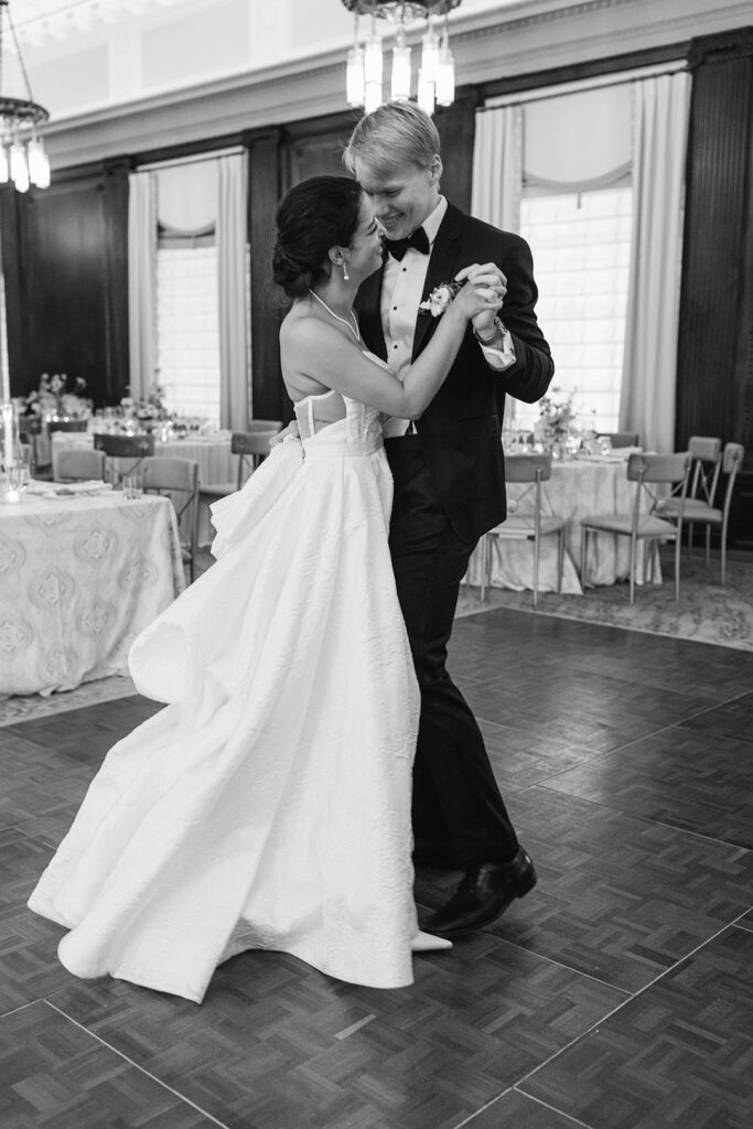 black and white of bride and groom dancing at reception.