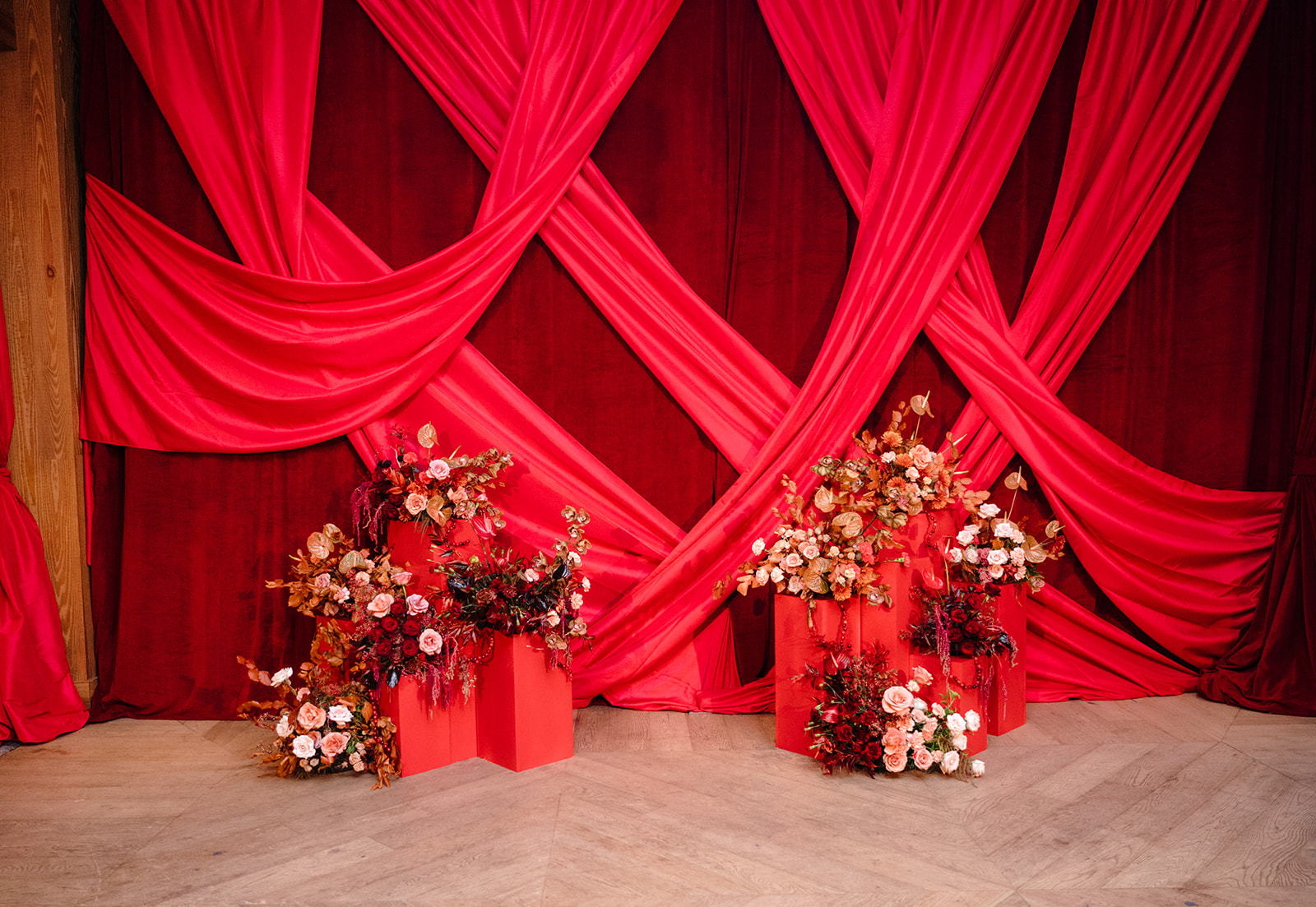 red carpet photo set up with red drapery and flowers 