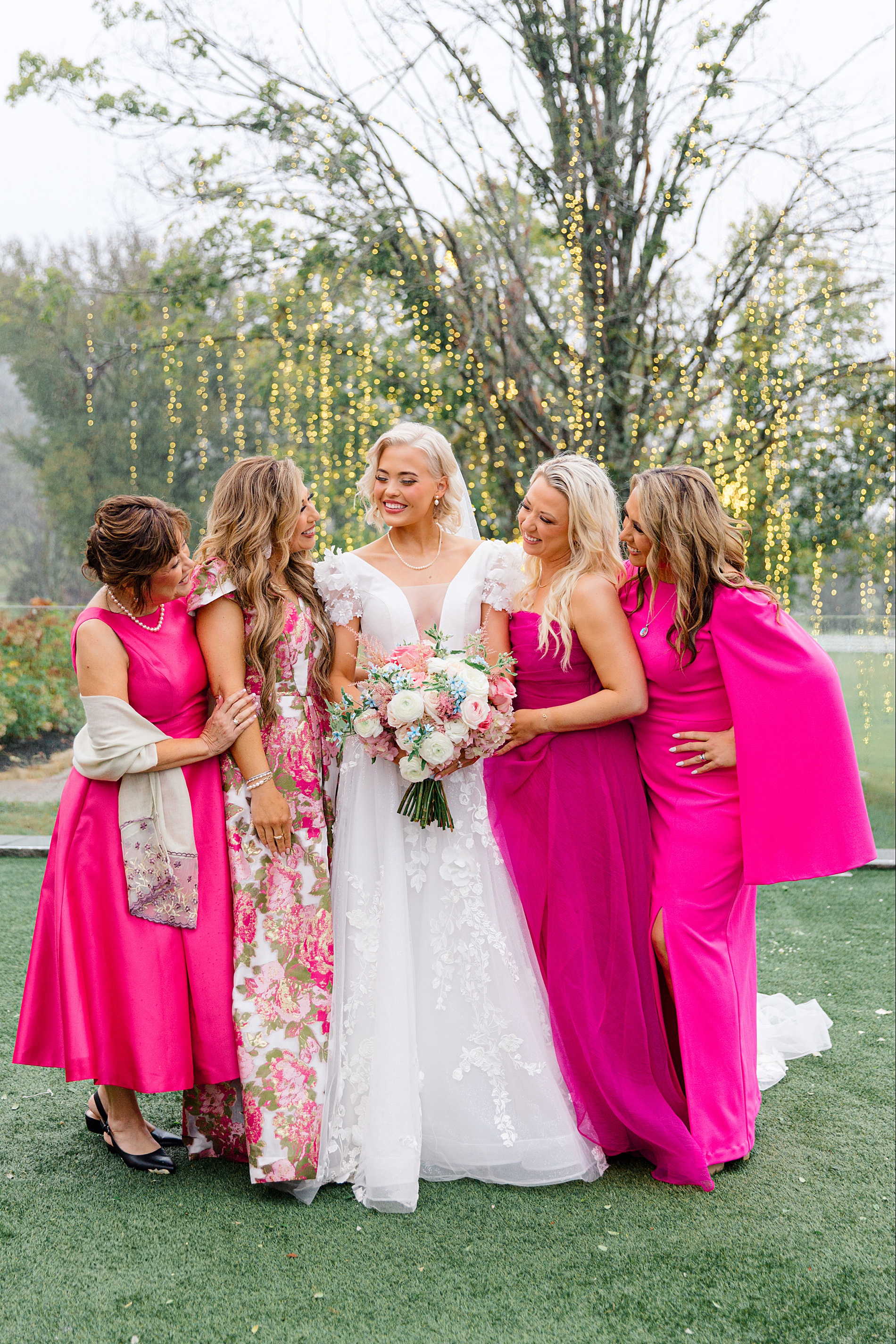 bride surrounded by women in pink dresses