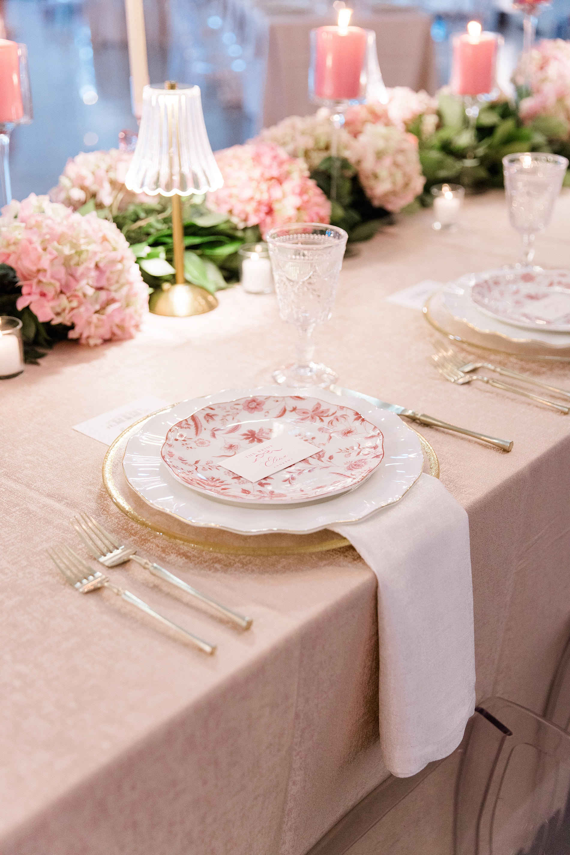 elegant place settings with pink floral plates sitting on a white plate 