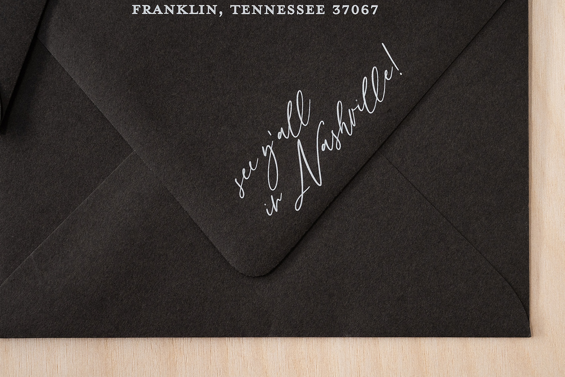 black envelope with "See Ya'll in Nashville" written on the flap