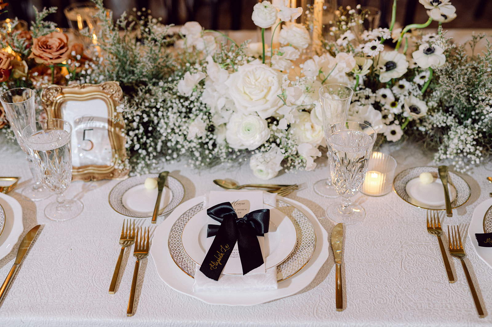 black ribbon place cards tied around custom menus featuring hand lettered hot foiled calligraphy  