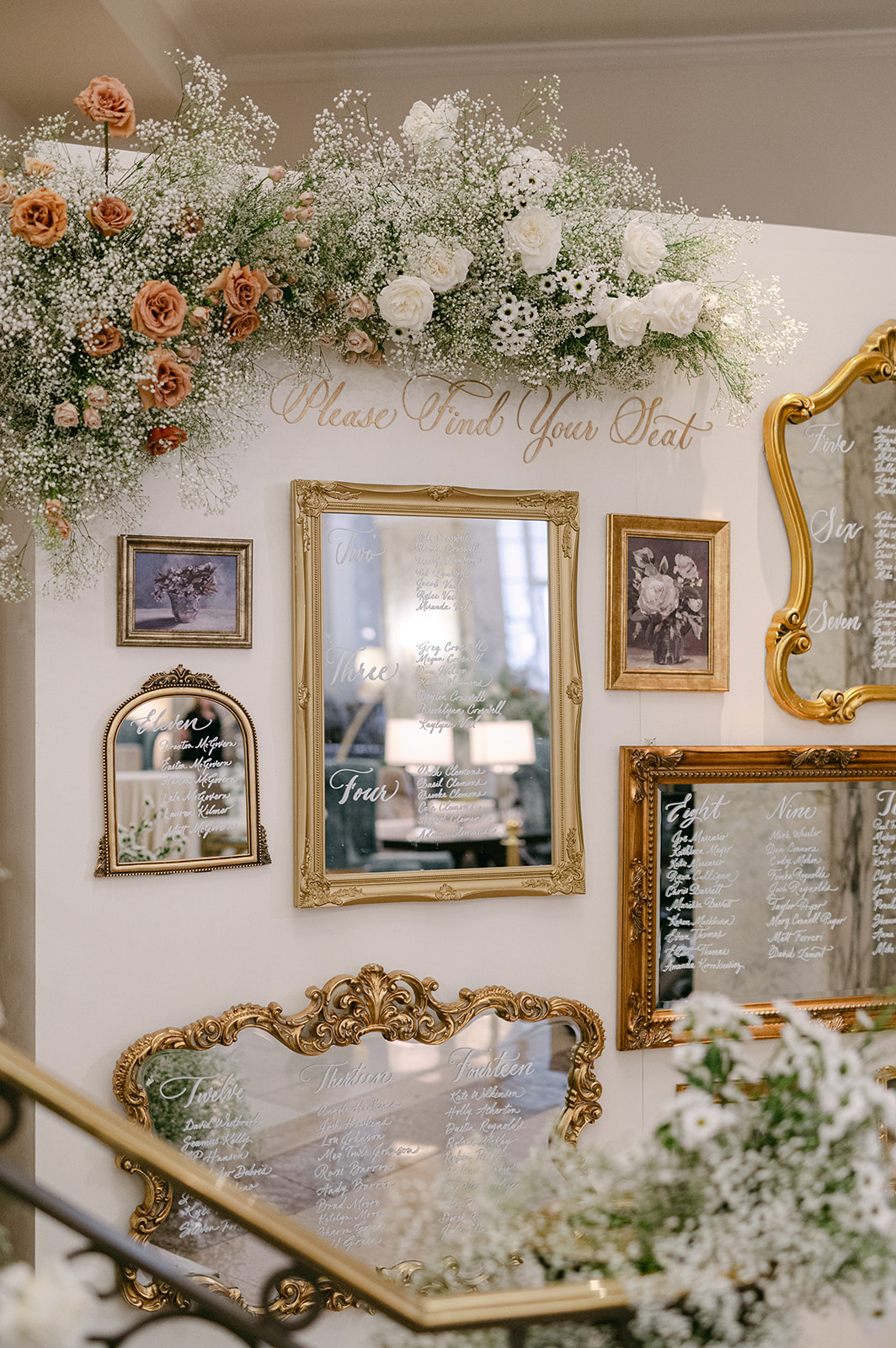 gold framed mirror seating chart in white calligraphy 